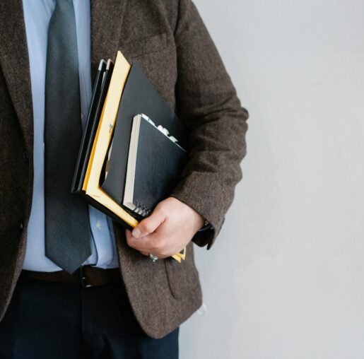 Crop unrecognizable office worker standing with papers in hand